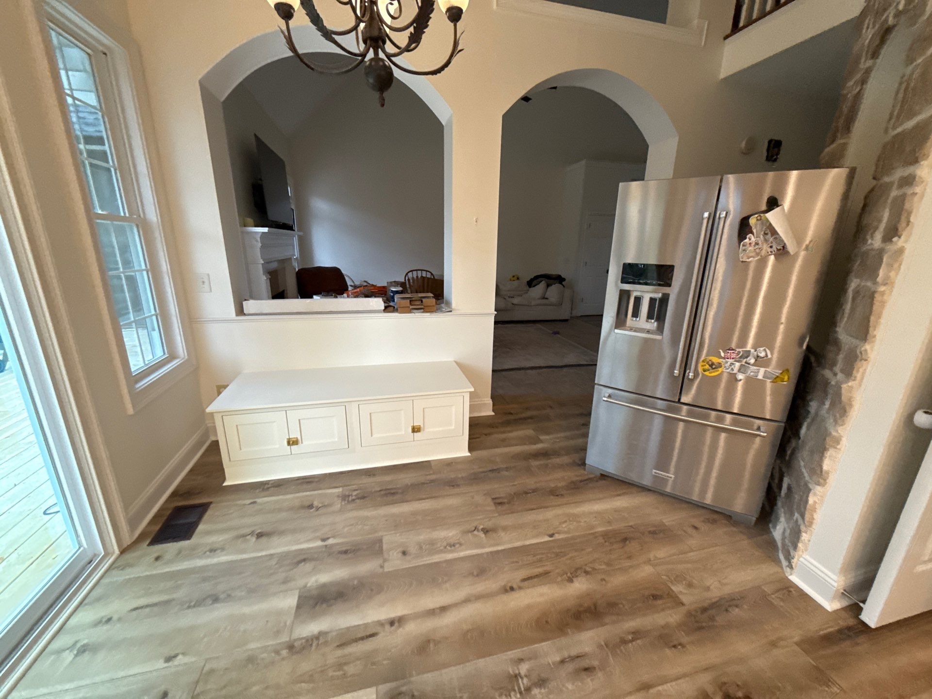 Kitchen renovation after โ new hardwood floors, white bench cabinet with gold hardware, arched doorways โ Powder Springs, GA, Estate Solutions