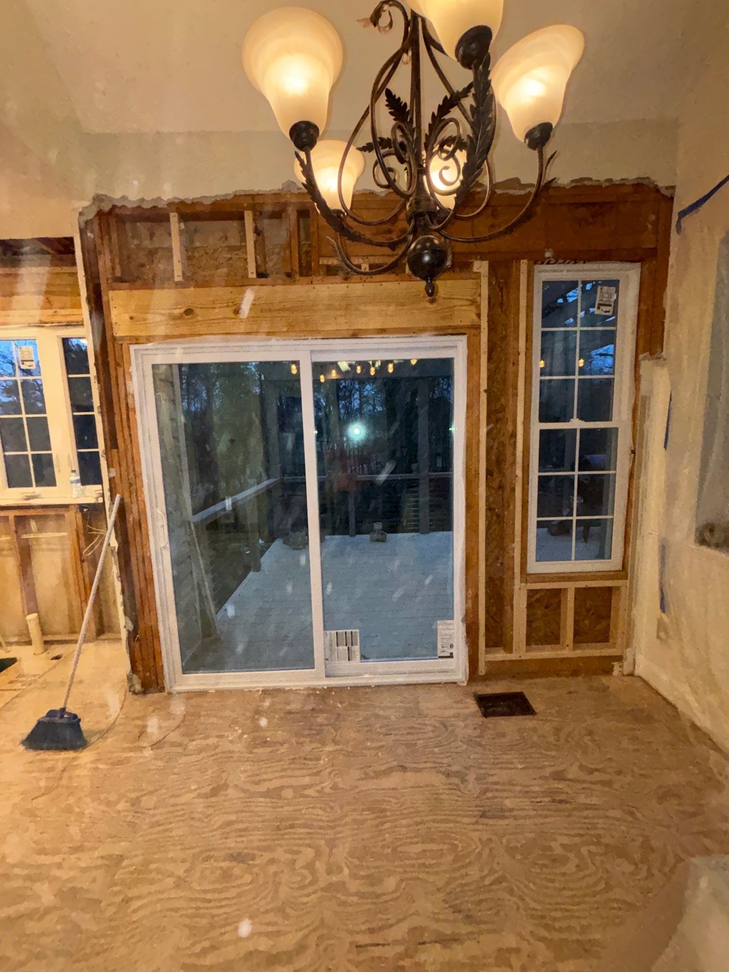 Dining area wall framing โ new sliding glass door rough-opened in exterior wall, chandelier retained during kitchen renovation โ Powder Springs, GA, Estate Solutions