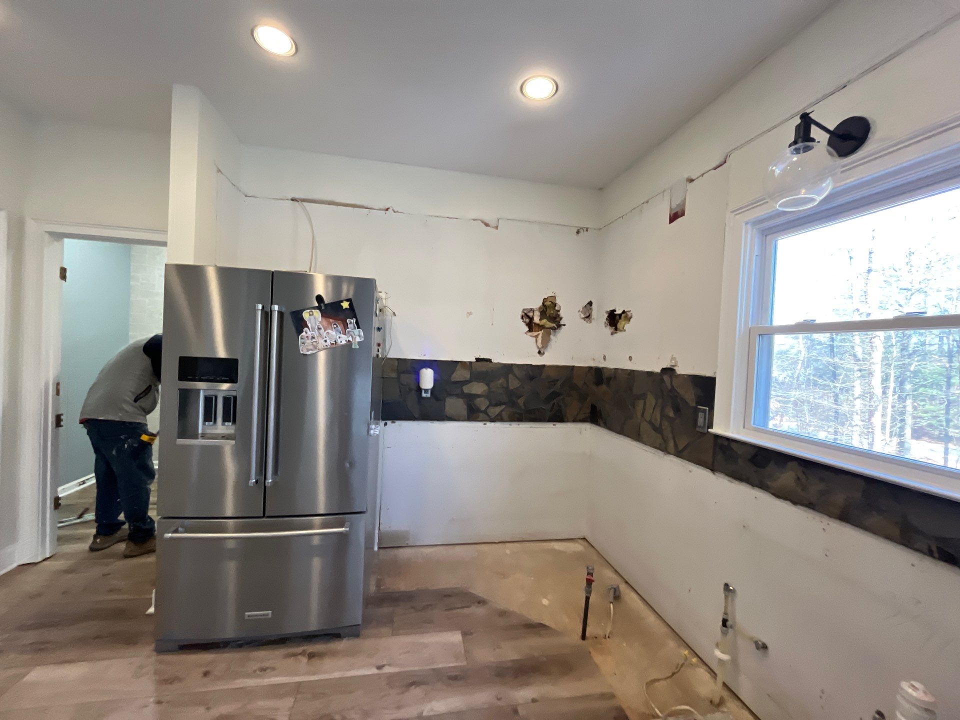 Kitchen demo in progress โ cabinets removed, stone backsplash being demolished, contractor working on gut renovation โ Powder Springs, GA, Estate Solutions