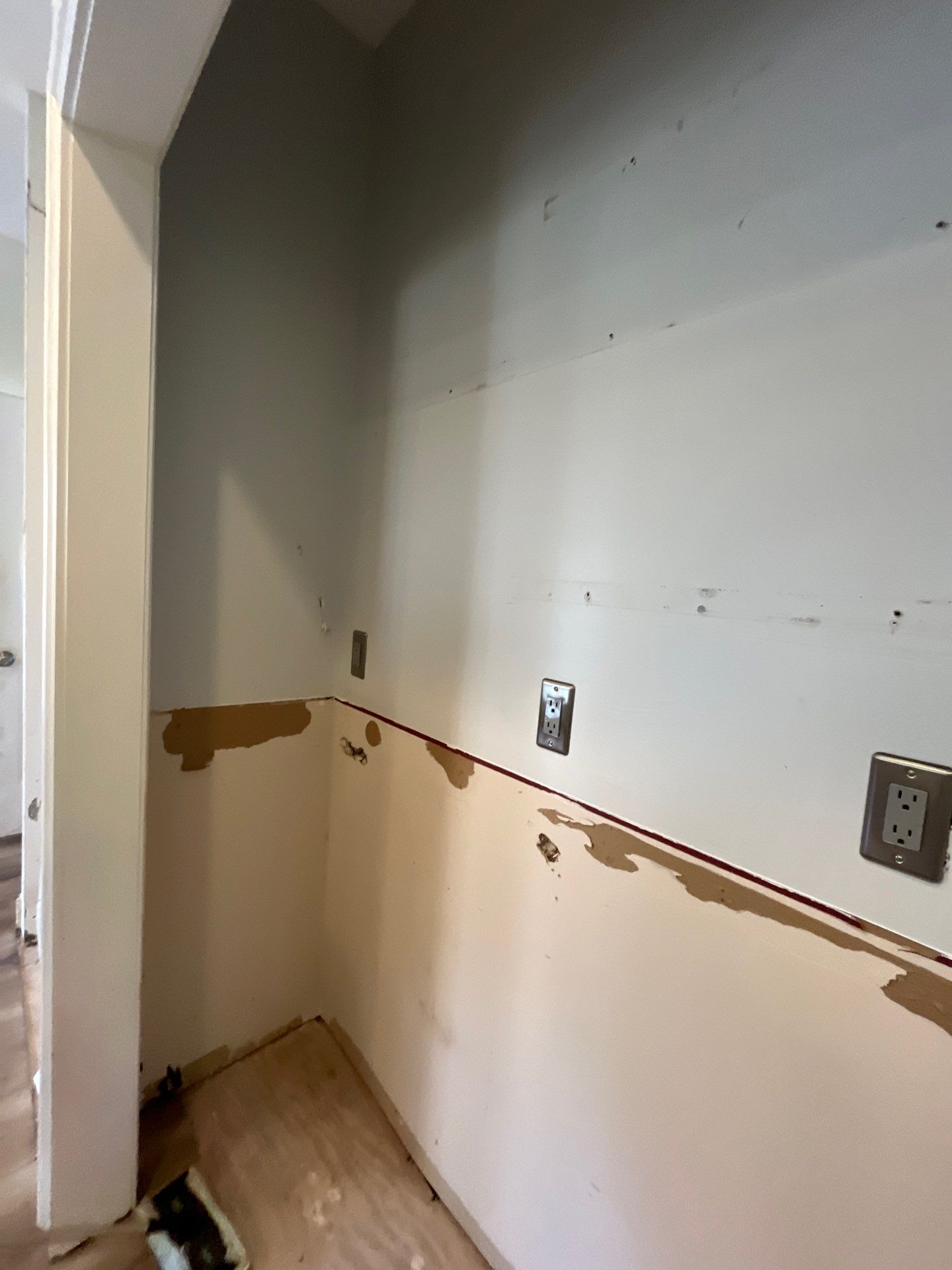 Kitchen wall after cabinet removal โ countertop area stripped to backerboard, electrical outlets exposed during demo โ Powder Springs, GA, Estate Solutions